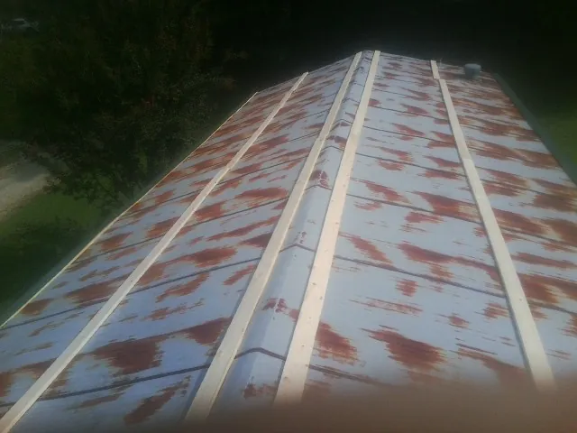 Rusted metal roof panels with new wood purlins before replacement — Storm Damage Roof Repair in Rosemont by Roofing Brothers