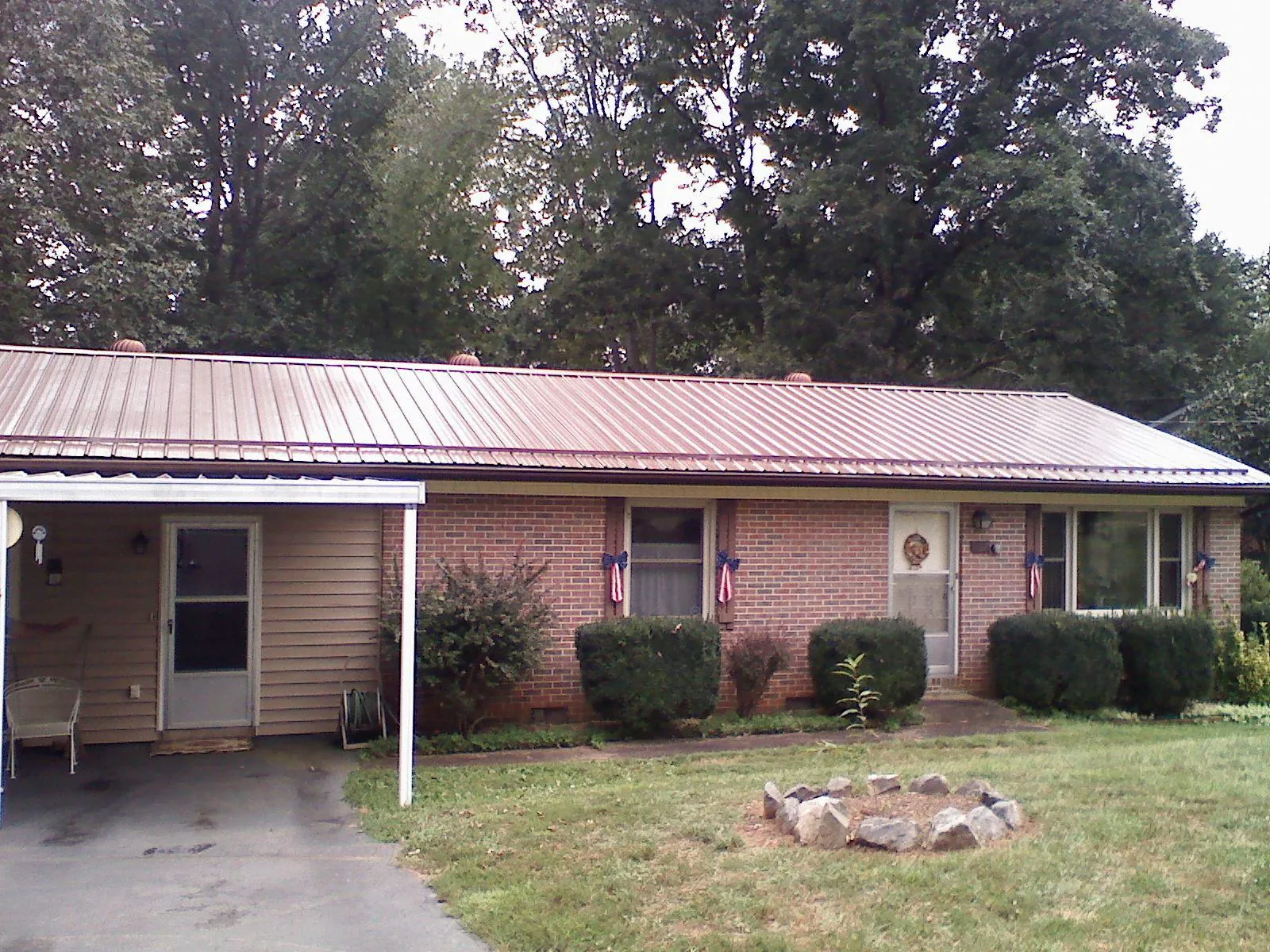 Bronze metal roof and carport on a brick ranch home — Roof Repair work by our crew in Rosemont